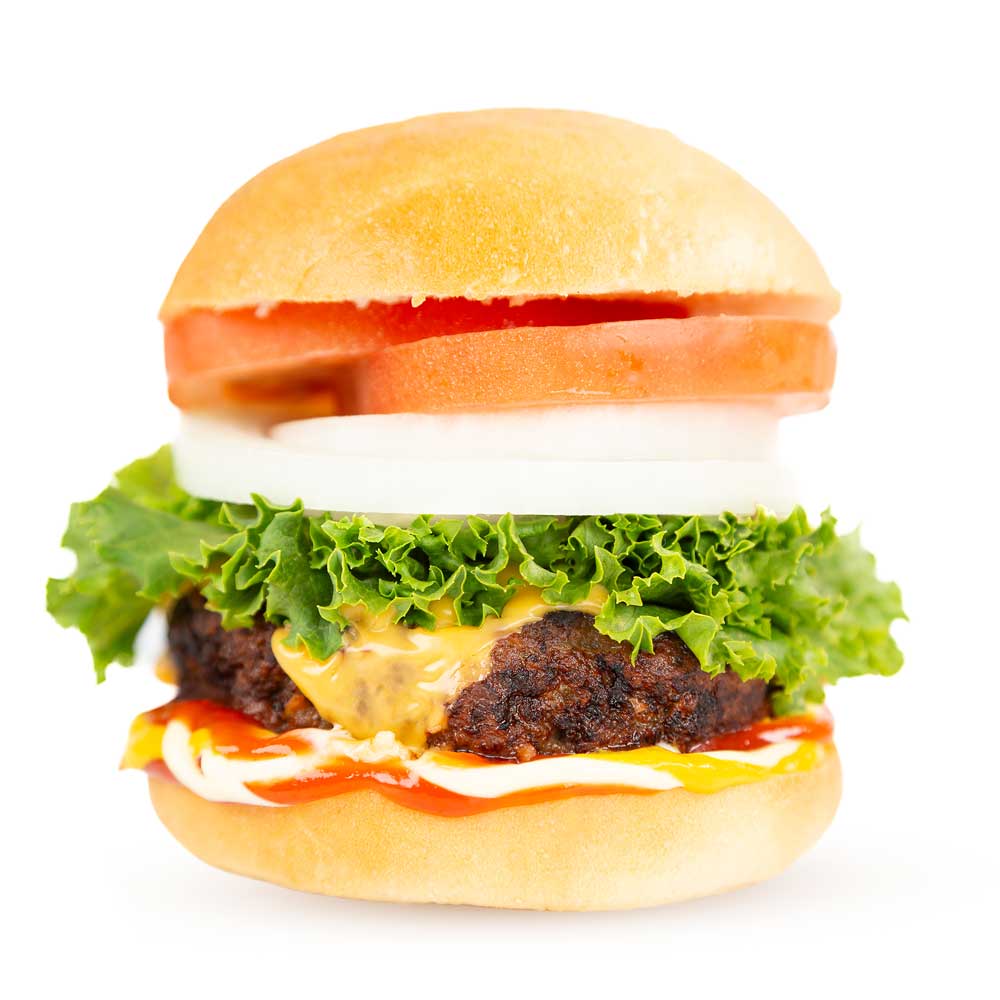 A close-up of a Maui-inspired hamburger with a beef patty, fresh lettuce, a slice of tomato, rings of onion, melted cheese, ketchup, and mayonnaise, all sandwiched between a lightly toasted bun from a local bakery. The toppings and condiments are vividly colorful and neatly arranged.