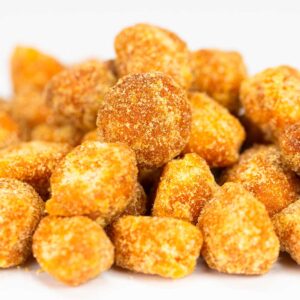 A close-up of a pile of golden-brown, sugar-coated Lilikoi Passion Macadamia Nuts, reminiscent of a treat you'd find in a Maui bakery. The irregularly shaped nuts glisten with their sugary coating, creating a crunchy texture against the plain white background.
