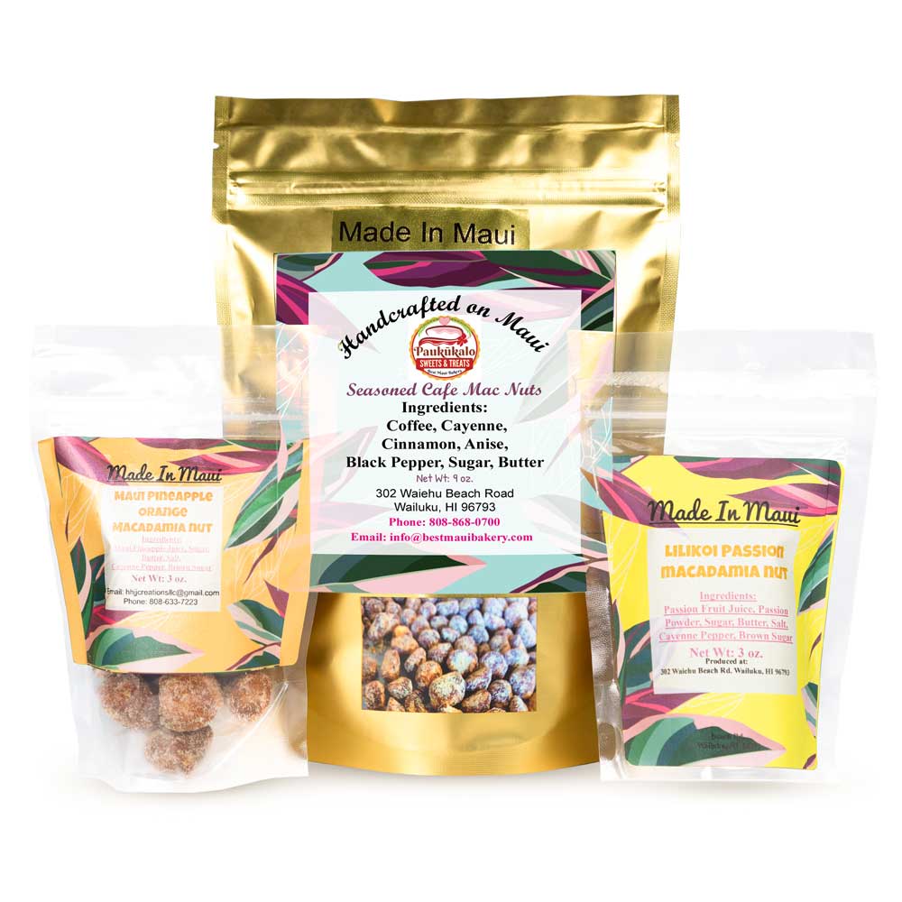 Three packages of macadamia nuts are displayed. The largest, centered, is labeled "Handcrafted on Maui Seasoned Cafe Mac Nuts" with an ingredients list visible. Two smaller packages on either side from a local bakery are labeled "Maui Pineapple Orange Macadamia Nut" and "Lilikoi Passion Macadamia Nut.